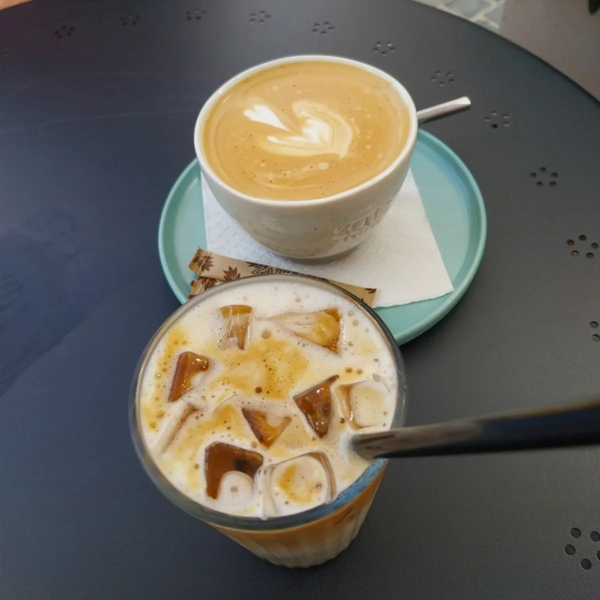 Flat white și iced latte ZATZ pe masa de pe terasă